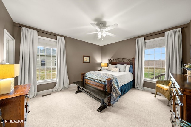 carpeted bedroom with visible vents, ceiling fan, and baseboards