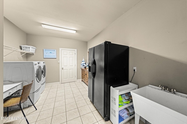 laundry room with laundry area, baseboards, washing machine and dryer, a sink, and light tile patterned flooring