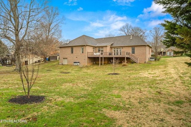 back of house featuring brick siding, a lawn, stairway, and a wooden deck