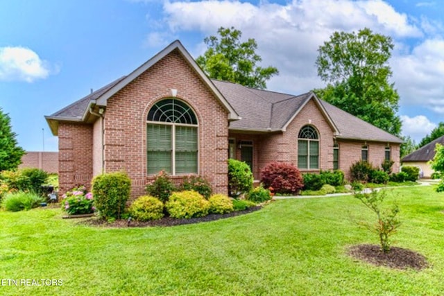 ranch-style house with brick siding and a front lawn