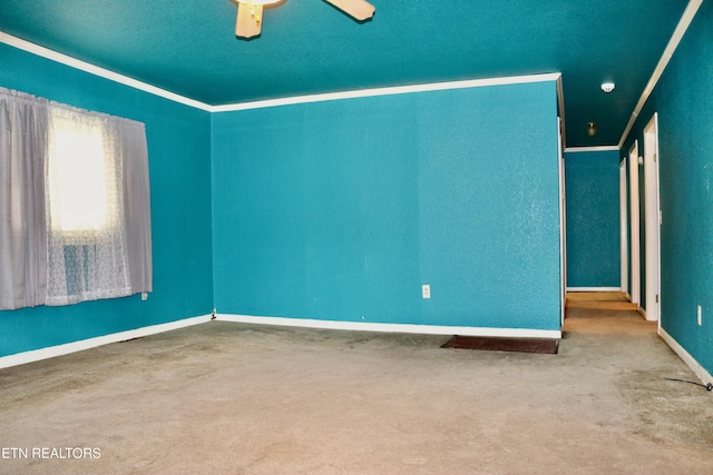 spare room with ceiling fan, ornamental molding, carpet, and baseboards