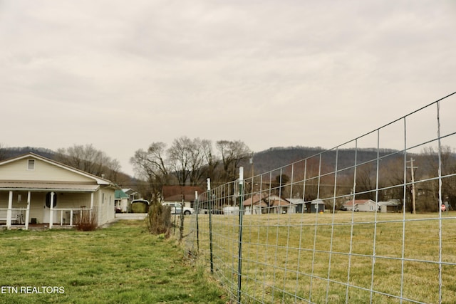 view of yard featuring a porch and fence