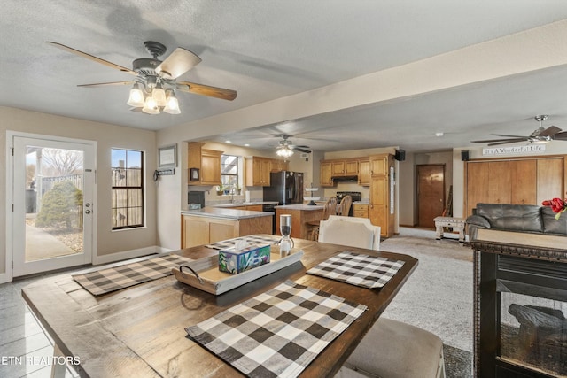 dining space with a textured ceiling, ceiling fan, and baseboards