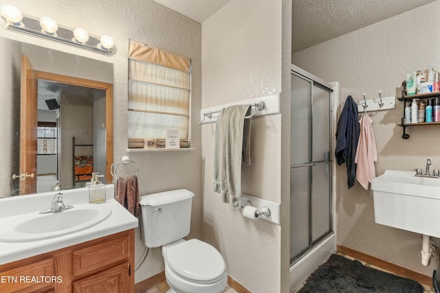 full bath with baseboards, a textured wall, a shower stall, and toilet