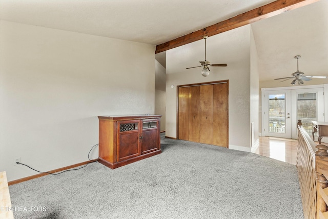 living room with light carpet, ceiling fan, lofted ceiling with beams, and baseboards