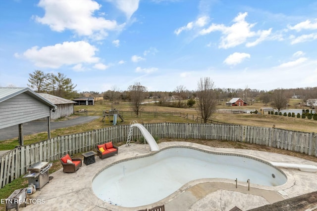 view of pool with a fenced backyard and a patio