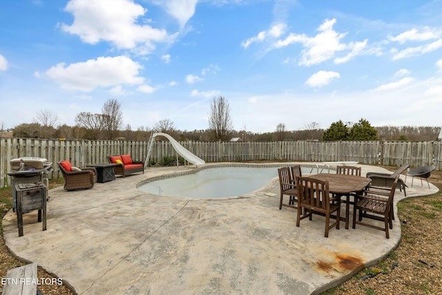 view of pool with a patio area, a fenced backyard, and a water slide