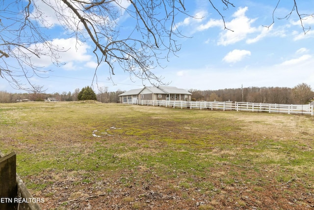 view of yard featuring a rural view and fence