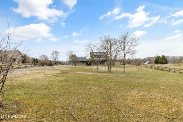 view of yard with a rural view and fence