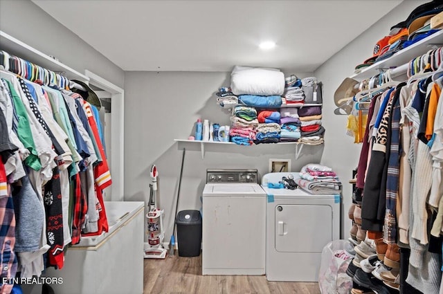 washroom featuring laundry area, light wood-style flooring, and washing machine and clothes dryer
