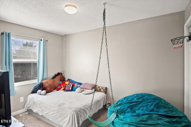 carpeted bedroom with visible vents, baseboards, and a textured ceiling