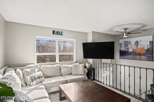 living area with a textured ceiling and ceiling fan