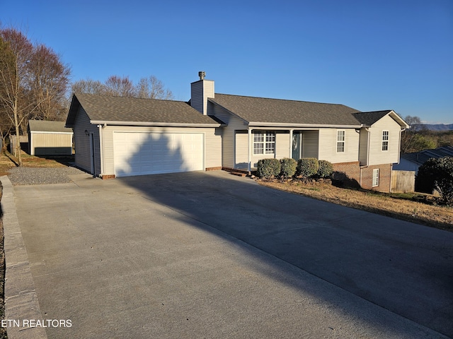 single story home with an attached garage, a shingled roof, a chimney, and concrete driveway