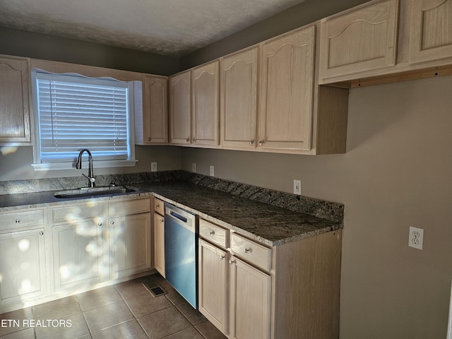 kitchen with dishwasher, light brown cabinetry, tile patterned flooring, and a sink