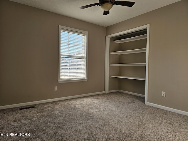 carpeted spare room with ceiling fan, a textured ceiling, visible vents, and baseboards