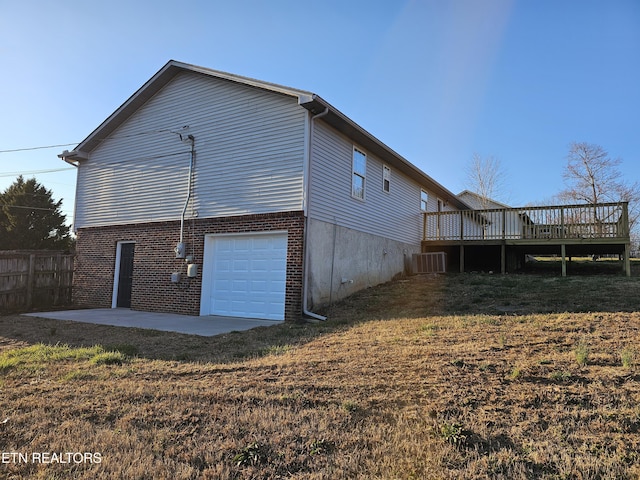 rear view of house featuring a yard, a patio, central AC, fence, and a garage