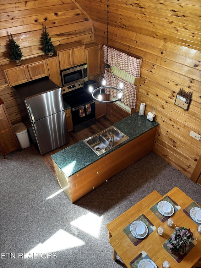 2234 Eagle Feather Dr, Sevierville, TN 37876 - kitchen with stainless steel appliances, wood walls, vaulted ceiling, a peninsula, and a sink