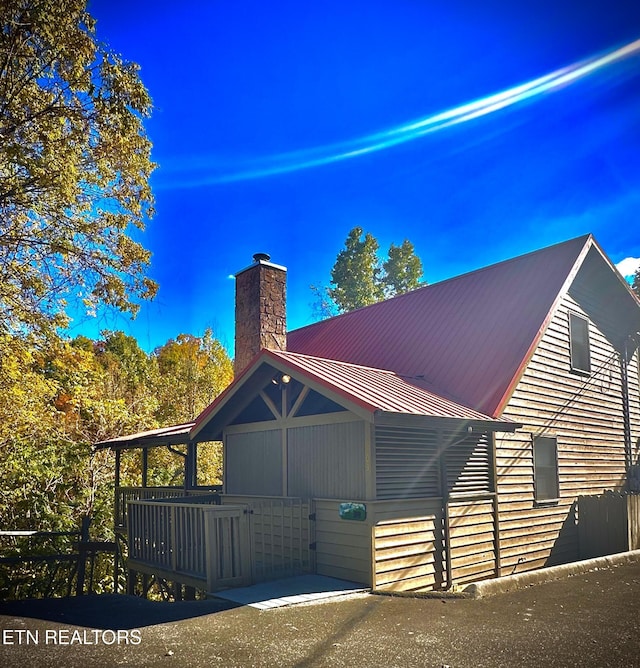 exterior space with a chimney and metal roof