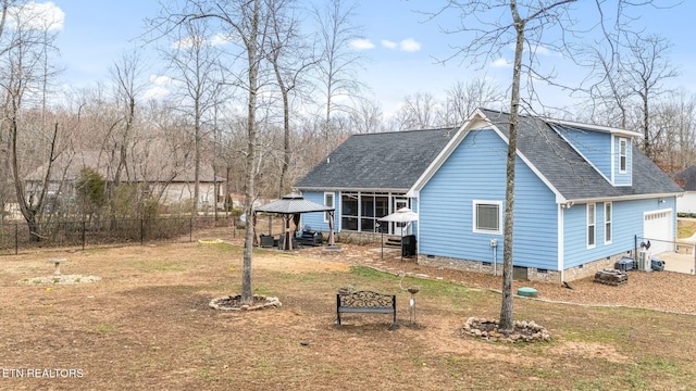 rear view of house with crawl space, fence, a gazebo, and a lawn