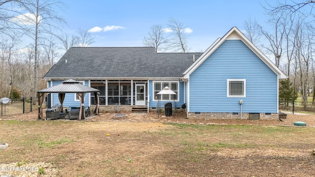 rear view of property featuring a shingled roof, fence, a sunroom, a yard, and crawl space