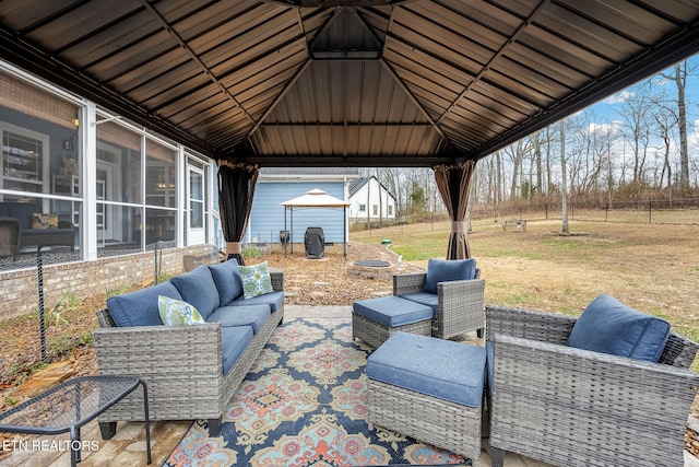 view of patio featuring an outbuilding, a sunroom, an outdoor living space, and a gazebo