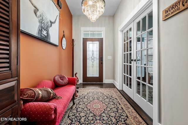 entrance foyer with baseboards, french doors, plenty of natural light, and a notable chandelier