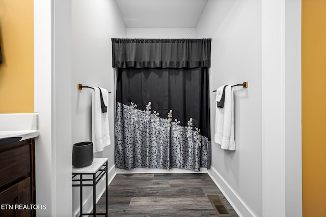 bathroom featuring visible vents, vanity, baseboards, and wood finished floors