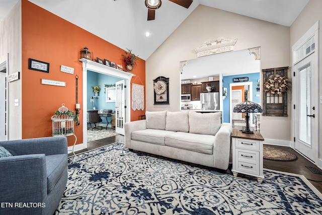 living area featuring high vaulted ceiling, wood finished floors, baseboards, and a ceiling fan