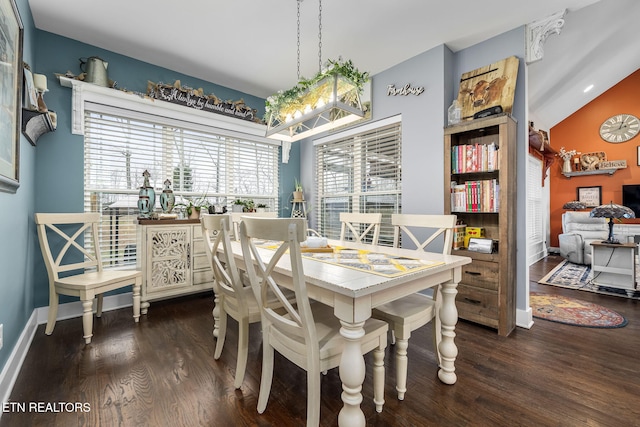 dining area featuring vaulted ceiling, wood finished floors, and baseboards