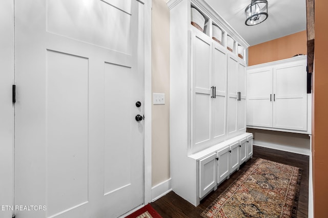 mudroom with dark wood-type flooring and baseboards