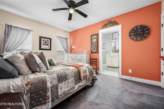 bedroom with carpet floors, a ceiling fan, baseboards, and ensuite bathroom