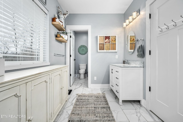 full bathroom with marble finish floor, vanity, toilet, and baseboards