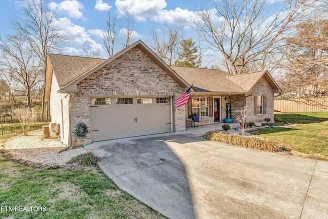 ranch-style home featuring roof with shingles, concrete driveway, an attached garage, fence, and a front lawn