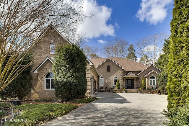 view of front of house with driveway and brick siding