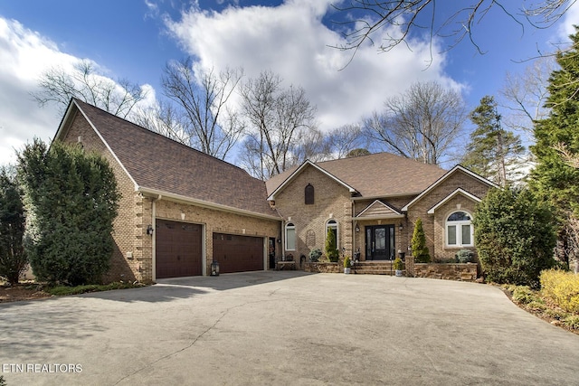 view of front of house with a garage, driveway, brick siding, and a shingled roof