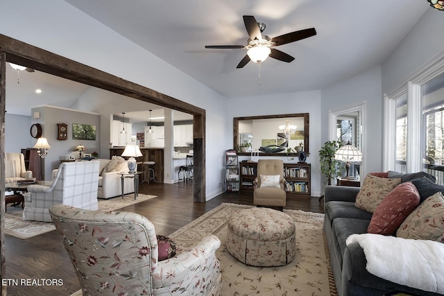 living area featuring ceiling fan with notable chandelier, wood finished floors, and baseboards