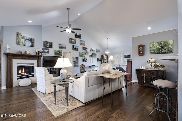 living room with high vaulted ceiling, recessed lighting, a ceiling fan, dark wood-style floors, and a glass covered fireplace