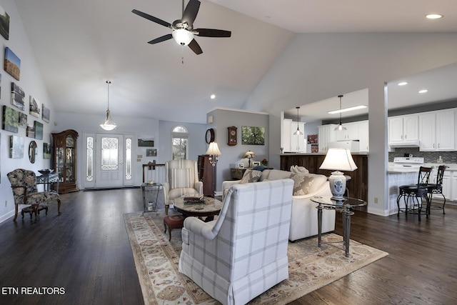 living area with baseboards, ceiling fan, dark wood-style flooring, high vaulted ceiling, and recessed lighting