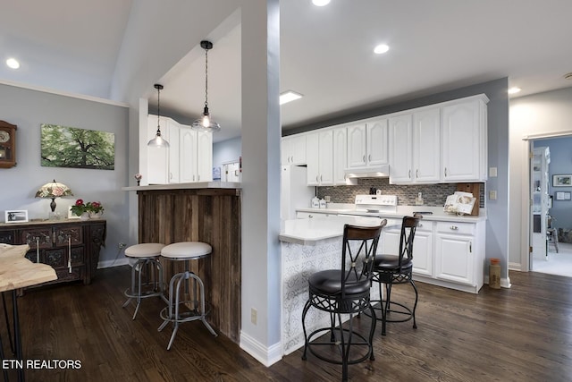 kitchen featuring tasteful backsplash, electric range, white cabinetry, and a kitchen breakfast bar