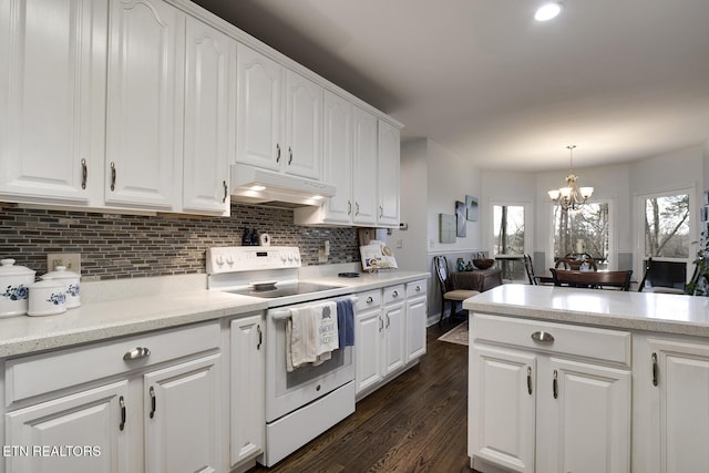 kitchen featuring a wealth of natural light, white electric range, white cabinets, a chandelier, and under cabinet range hood