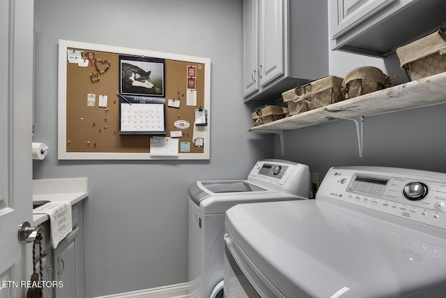 washroom featuring cabinet space and washer and clothes dryer