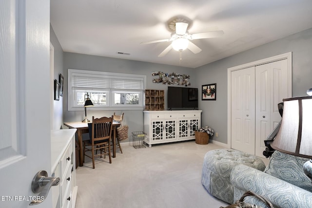 interior space with ceiling fan, baseboards, visible vents, and light colored carpet