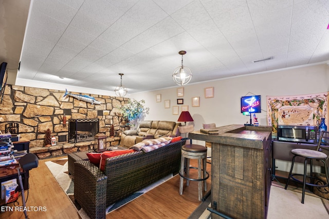 living room with a dry bar, visible vents, ornamental molding, and wood finished floors