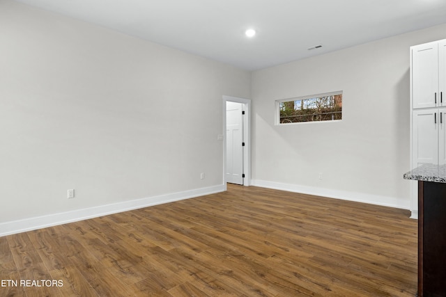 unfurnished room with recessed lighting, baseboards, and wood finished floors