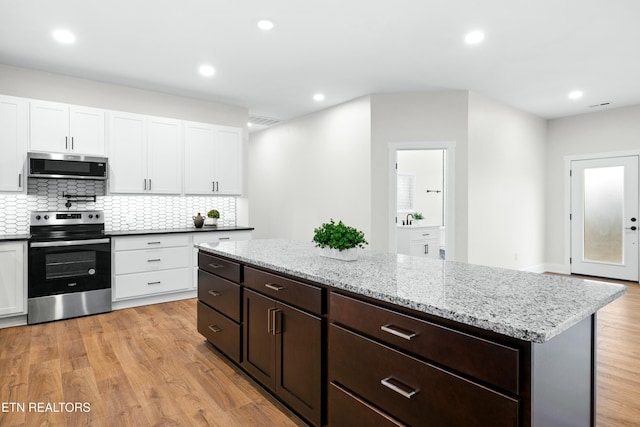 kitchen with white cabinetry, visible vents, light wood-style floors, appliances with stainless steel finishes, and tasteful backsplash