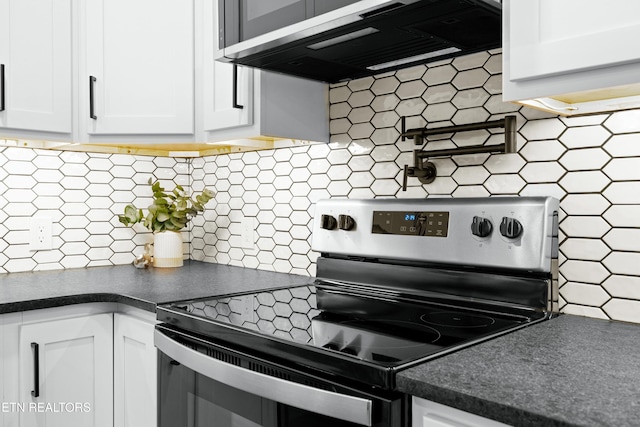 kitchen with tasteful backsplash, dark countertops, stainless steel electric stove, extractor fan, and white cabinetry