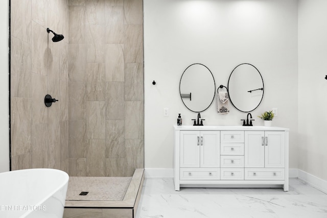 bathroom with marble finish floor, double vanity, a tile shower, and baseboards