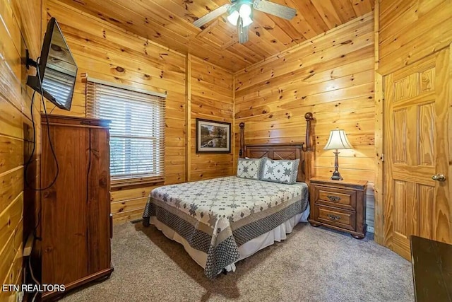 bedroom featuring wooden ceiling, light colored carpet, wood walls, and ceiling fan