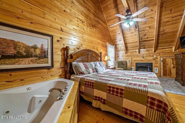 bedroom with lofted ceiling with beams, wood finished floors, wood ceiling, and wooden walls