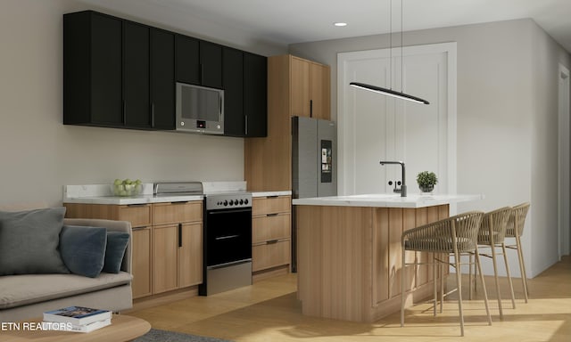 kitchen with light wood-style flooring, light countertops, dark cabinets, and range with electric stovetop